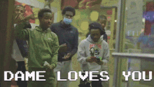 a group of people standing in front of a store with the words dame loves you on the bottom