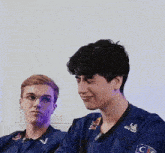 two young men are sitting next to each other and one of them is wearing a red bull shirt