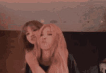 two girls are standing next to each other in a room .