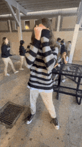 a girl in a striped sweater covering her face