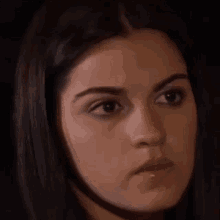 a close up of a woman 's face with a serious expression