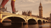 a person running on a bridge with a big ben in the background