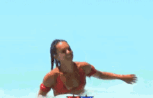a woman in a red bikini is running through the water