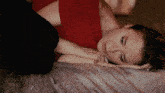 a woman is laying on a bed with her head on her hand