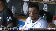 a baseball player with the number 54 on his jersey is sitting in the dugout