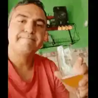 a man is holding a glass of beer and smiling .