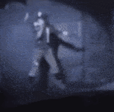 a blurry picture of a person standing in the dark .