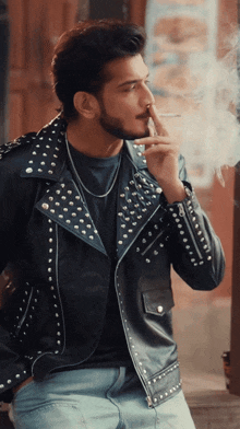 a man in a leather jacket smoking a cigarette