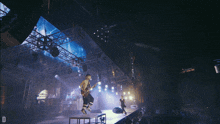 a man playing a guitar in front of a crowd with the letter d on the bottom