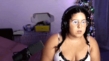 a woman wearing glasses and headphones is standing in front of a microphone