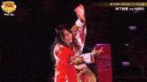 a woman in a red and gold outfit holds a banner that says rs