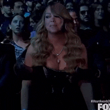 a woman with blue hair is sitting in front of a crowd at a heart awards show