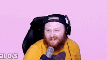 a man with a beard wearing headphones and a yellow shirt with a bear on it