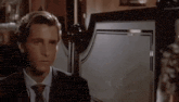 a man in a suit and tie is making a face in a bar .