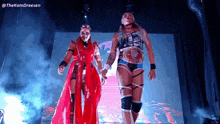 a man and a woman are walking on stage holding hands .