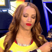 a woman wearing a yellow shirt and a necklace with the name sasha on it