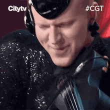 a man wearing headphones playing a violin with the hashtag #cgt above him