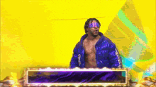 a man in a blue jacket with the number 2 on it stands in front of a yellow background