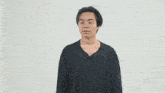 a young man wearing glasses and a black shirt is standing with his hands on his hips