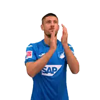 a man wearing a blue jersey with the word joma on it is clapping his hands