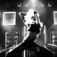 a black and white photo of a woman in a bra dancing