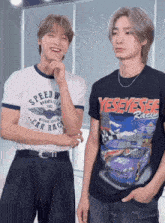 two young men standing next to each other one wearing a speedway car race shirt