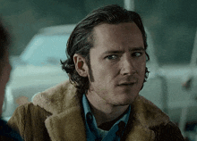 a close up of a man 's face with a furry jacket on