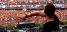 a dj is playing music in front of a crowd with the words " its-getting-wild.com " on the bottom