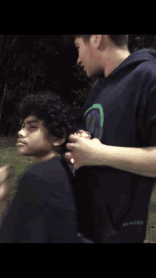 a man in a black shirt with a green t on the sleeve