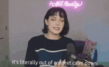 a woman is talking into a microphone and saying it 's literally out of context calm down
