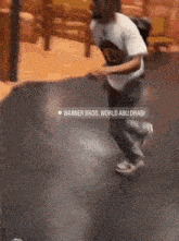 a blurred image of a person running with the words warner bros. world abu dhabi in the corner