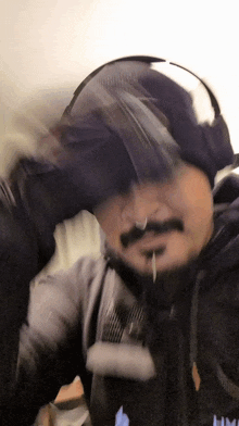 a man with a beard is wearing headphones and a jacket that says hm