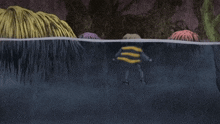 a person in a yellow and black shirt is swimming in a body of water
