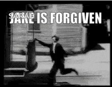 a black and white photo of a man running in front of a building with the words `` sarah jane is forgiven '' .