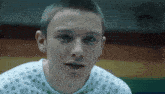 a young man is wearing a hospital gown with polka dots