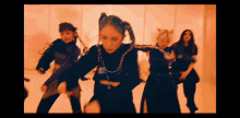 a group of women are dancing in a room with red lights