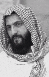 a black and white photo of a man with a beard wearing a scarf around his head