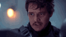 a close up of a man with a mustache looking at something .