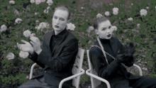a man and a woman are sitting next to each other on a park bench