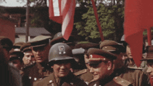 a man wearing a helmet with the letter s on it stands in a crowd