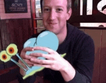 a man holding a cartoon snail in front of a sign that says sydney