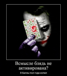 a poster of the joker holding a playing card in front of his face .