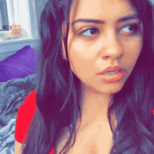 a woman with long dark hair is looking at the camera