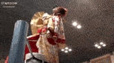 a woman in a kimono is standing in a ring with the word stardom on the bottom right