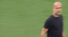 a man in a black shirt is standing next to a soccer player in a green jersey .