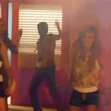 a man and a woman are dancing in front of a window