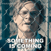 a man behind a chain link fence with something is coming