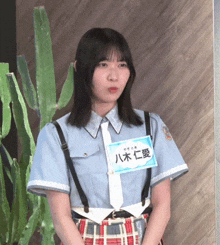 a girl wearing suspenders and a name tag that says ' 八木 仁愛 '