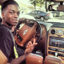 a young man sitting in a bentley giving the middle finger