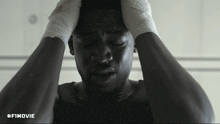 a black and white photo of a man with his hands on his head with the hashtag #fimovie